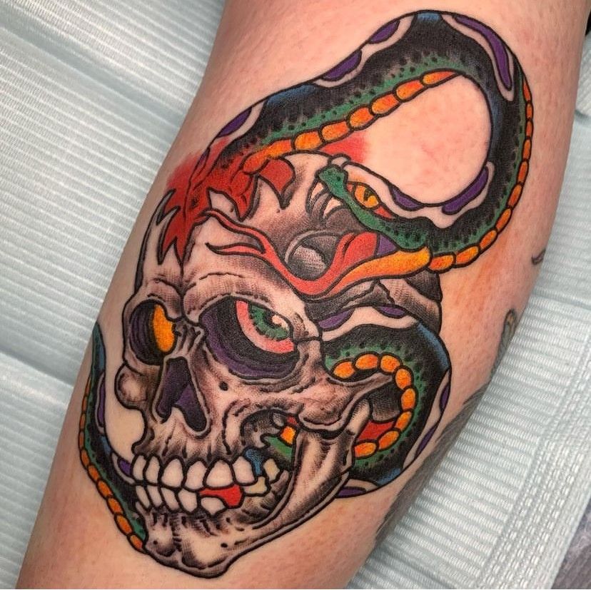 a tattoo of a skull with a snake around it