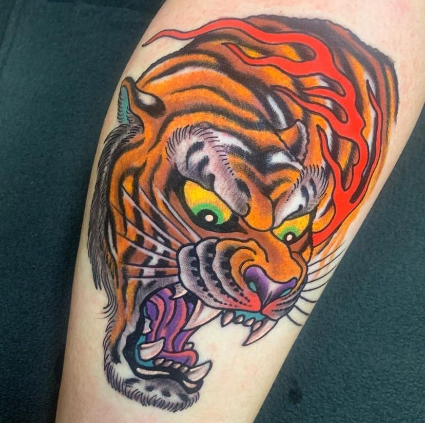 a tattoo of a tiger with flames coming out of its mouth