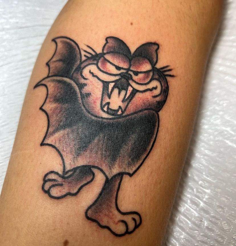 a person has a tattoo of garfield the bat on their arm