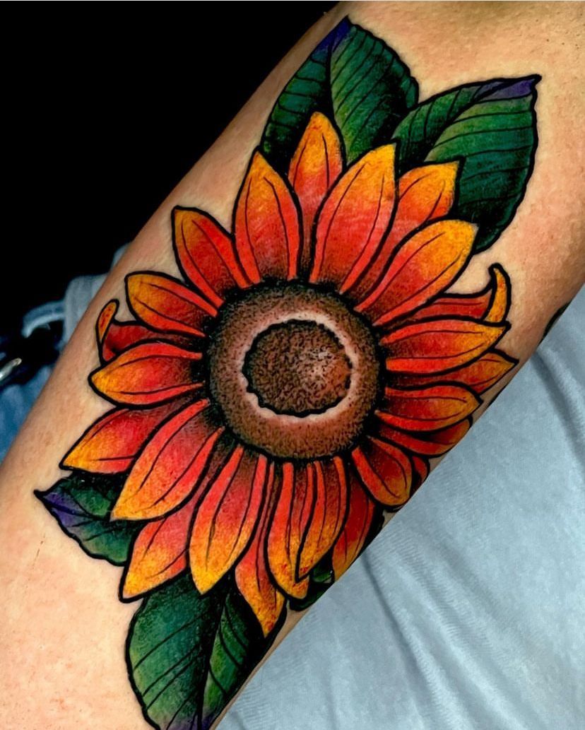 a person has a colorful sunflower tattoo on their arm