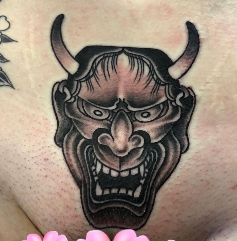 a person has a tattoo of a demon face with horns