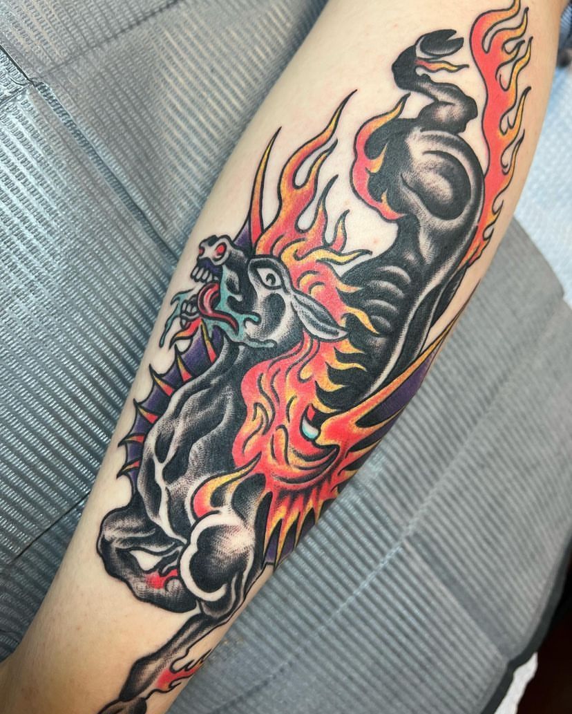 a tattoo of a horse with flames on its back