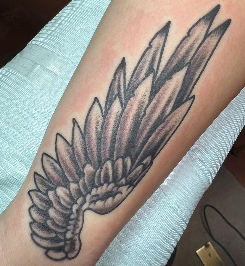 a tattoo of a bird wing on a person's arm