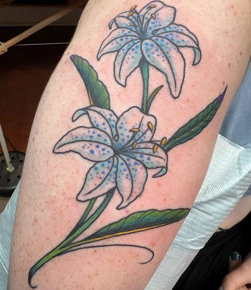 a person has a tattoo of two blue flowers on their arm