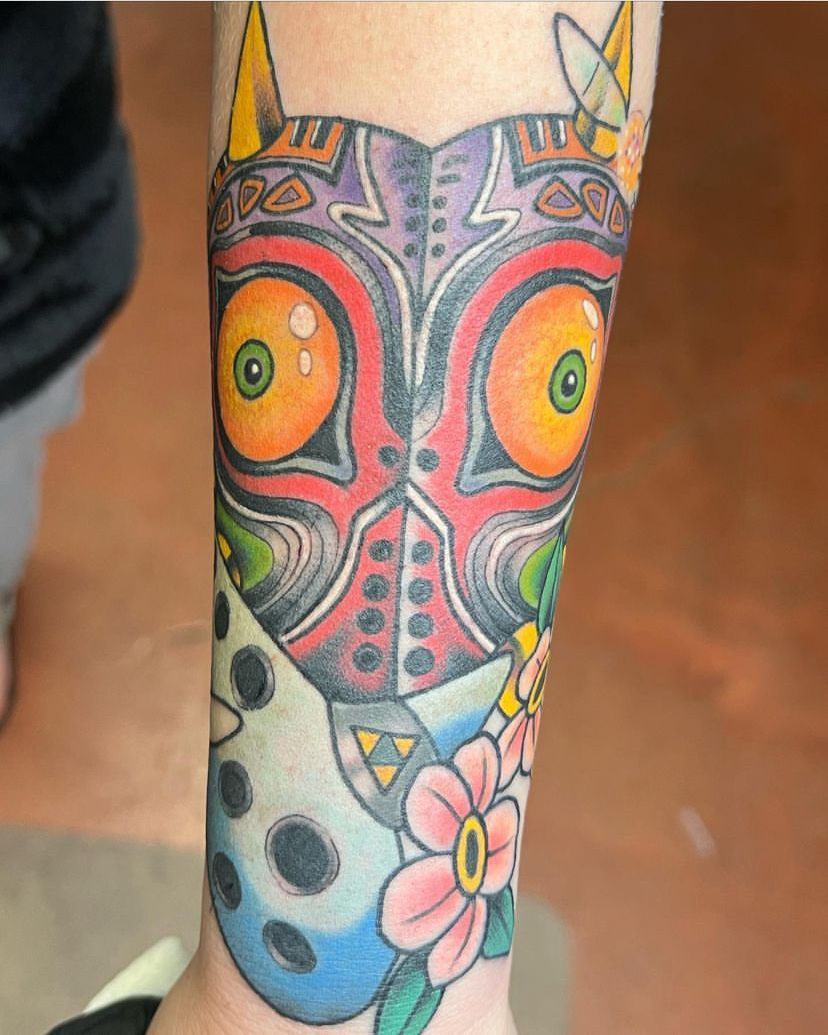 a person has a tattoo of a mask on their leg