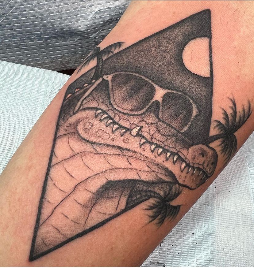 a black and white tattoo of a crocodile wearing sunglasses