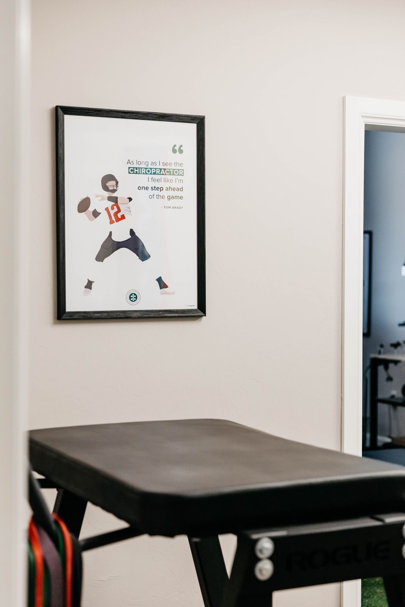 Clinic room with massage table and framed wall poster