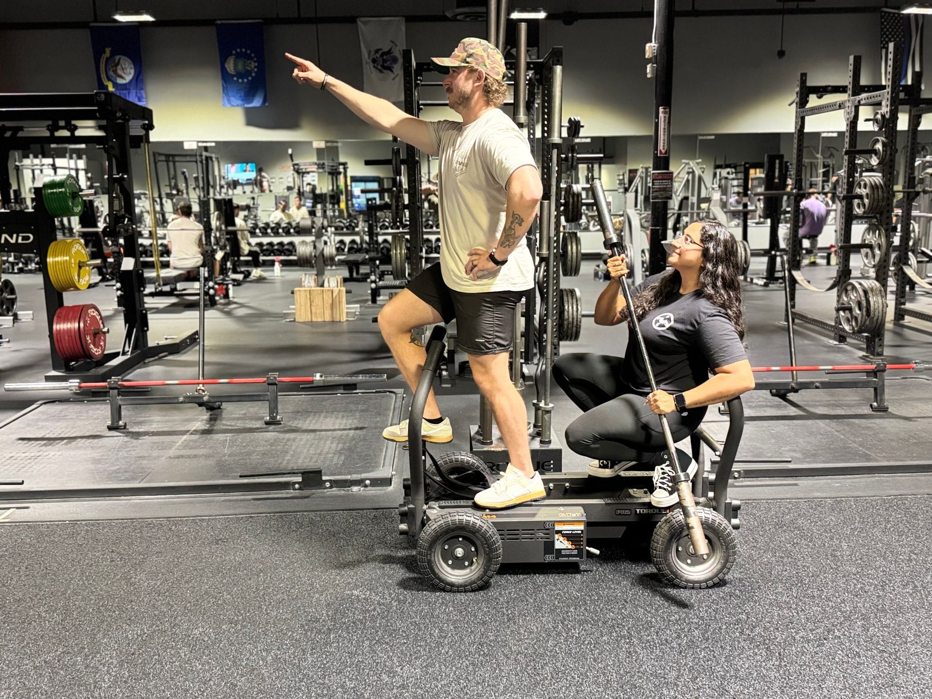 A man and a woman are standing next to each other in a gym.
