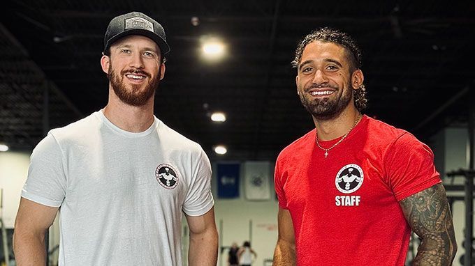Two men are standing next to each other in a gym