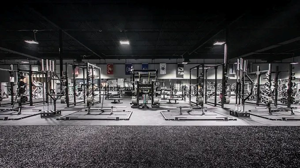 A large gym filled with lots of exercise equipment.