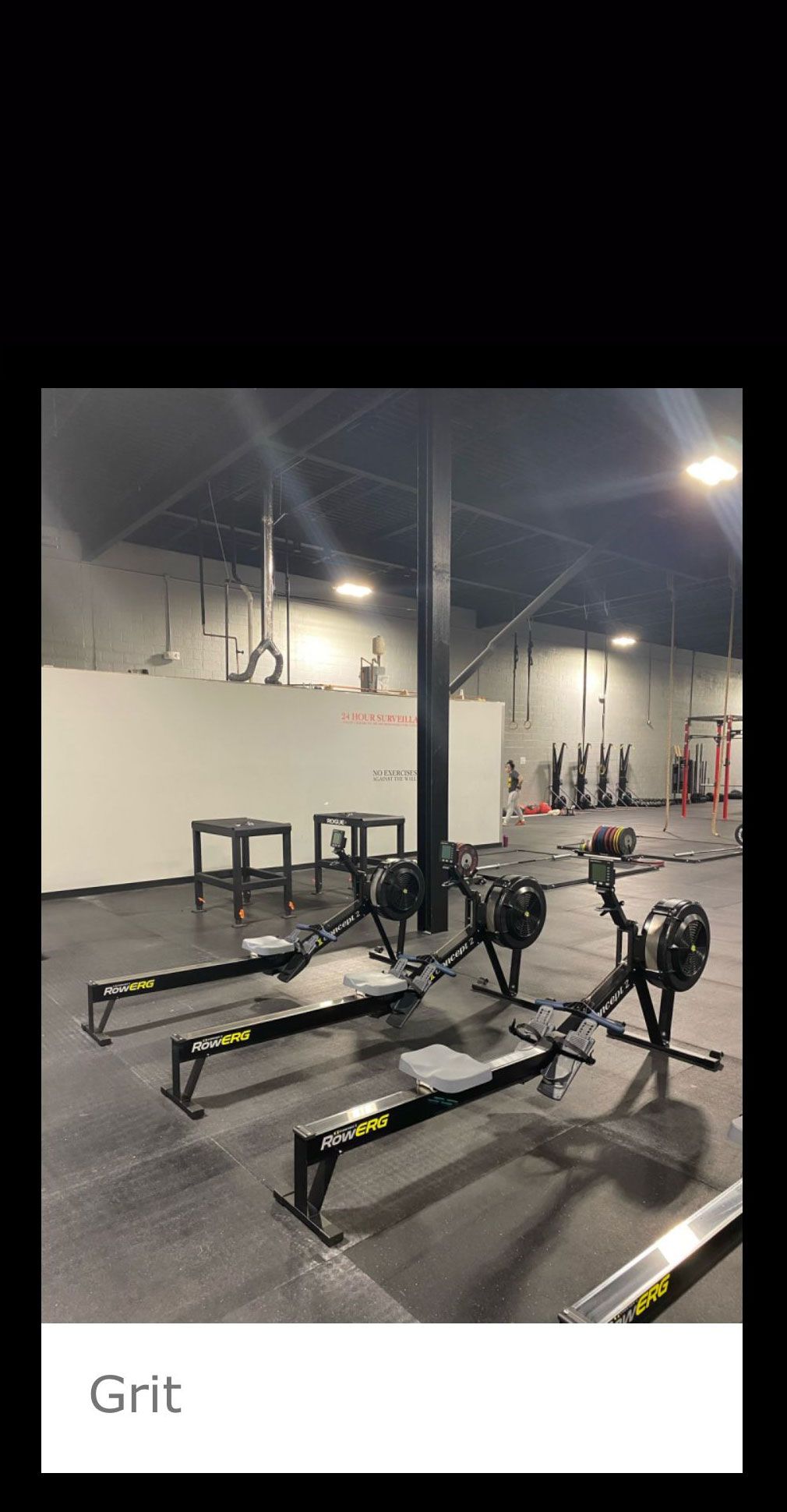 A row of rowing machines are lined up in a gym