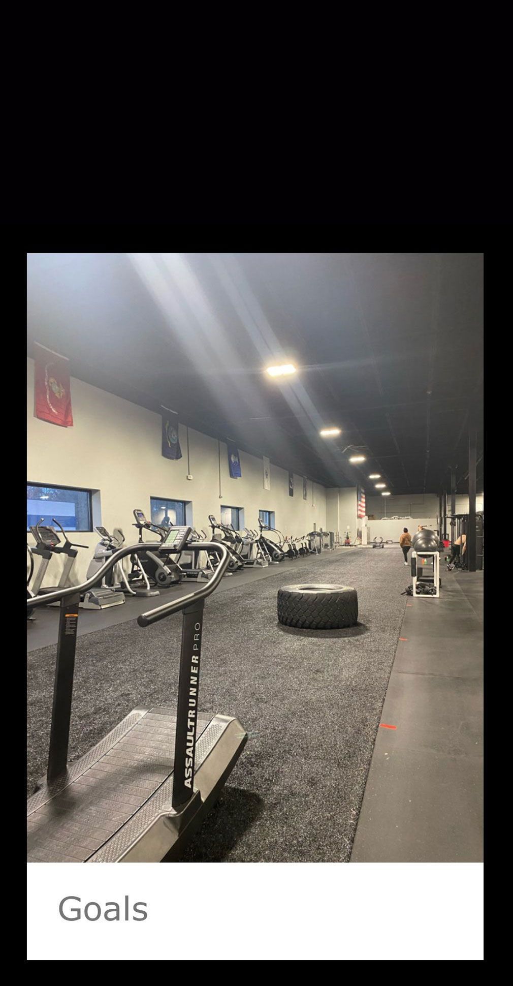 A gym with a lot of equipment and a tire on the floor