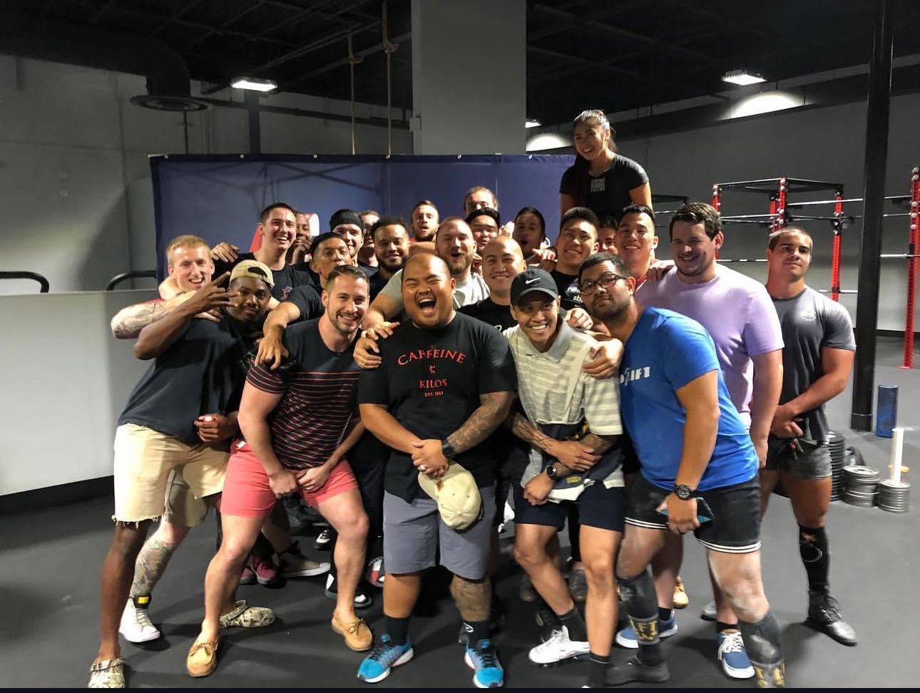 A group of men is posing for a picture in a gym