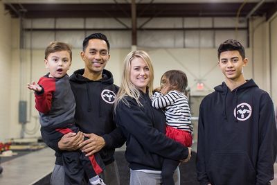 A family is posing for a picture in a gym.