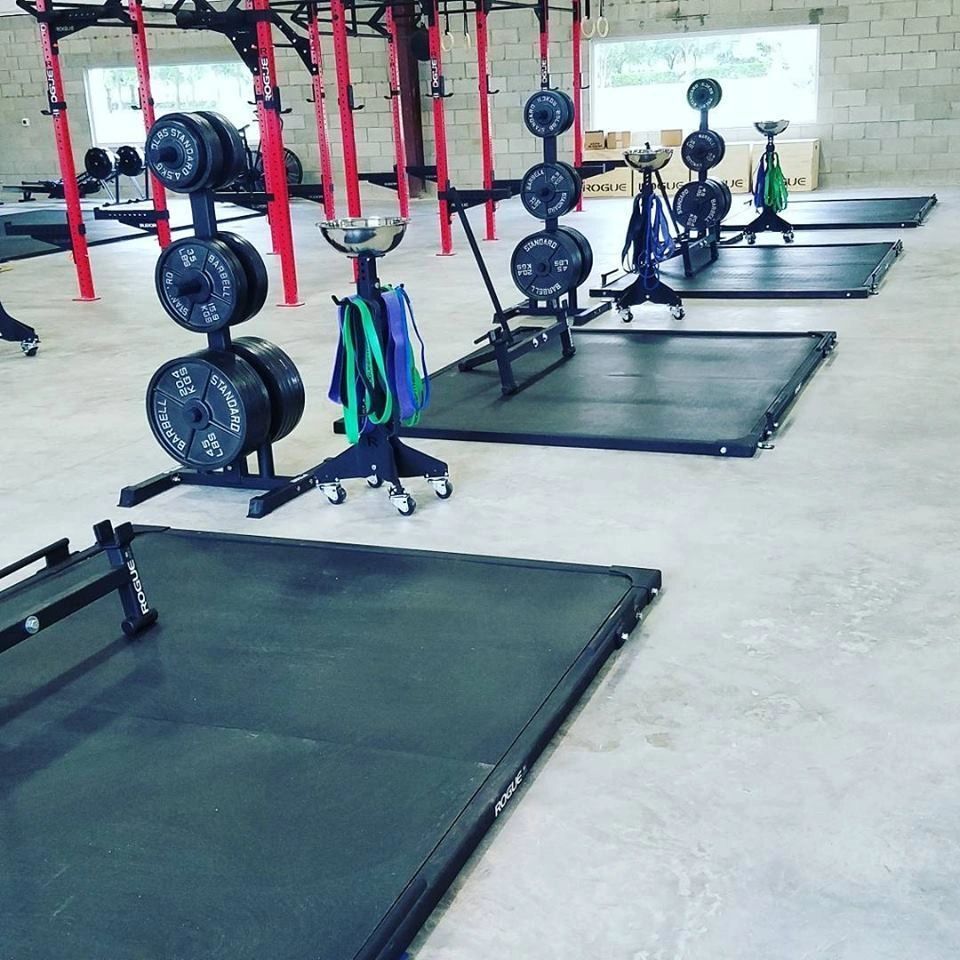 A gym with a lot of weights and mats