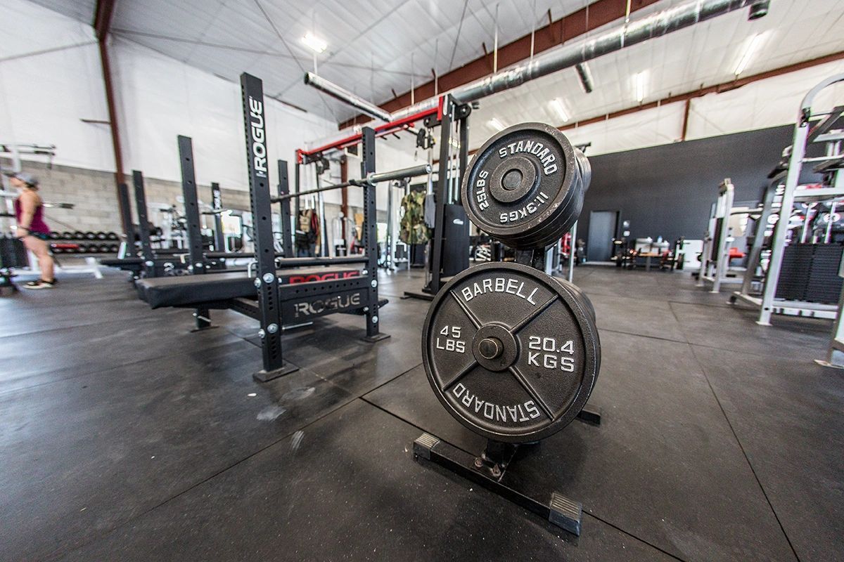 A gym with a bunch of weights on a rack.