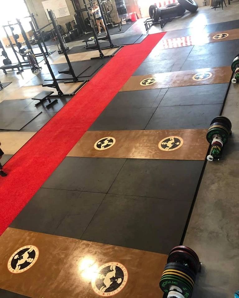 A gym with a red carpet and weights on the floor