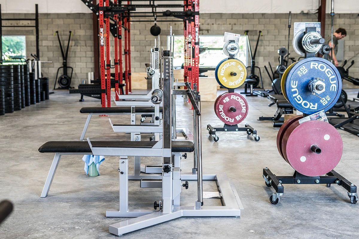 A gym filled with lots of exercise equipment and weights.