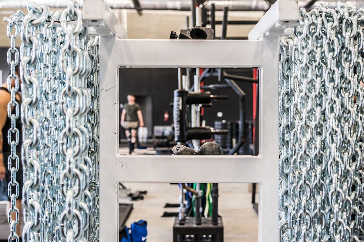 A gym with a lot of chains hanging from the ceiling.