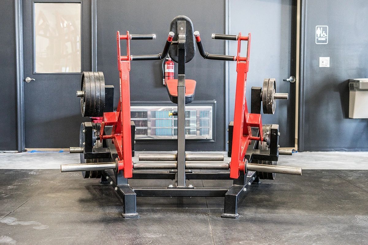 A red and black machine is sitting in a gym.
