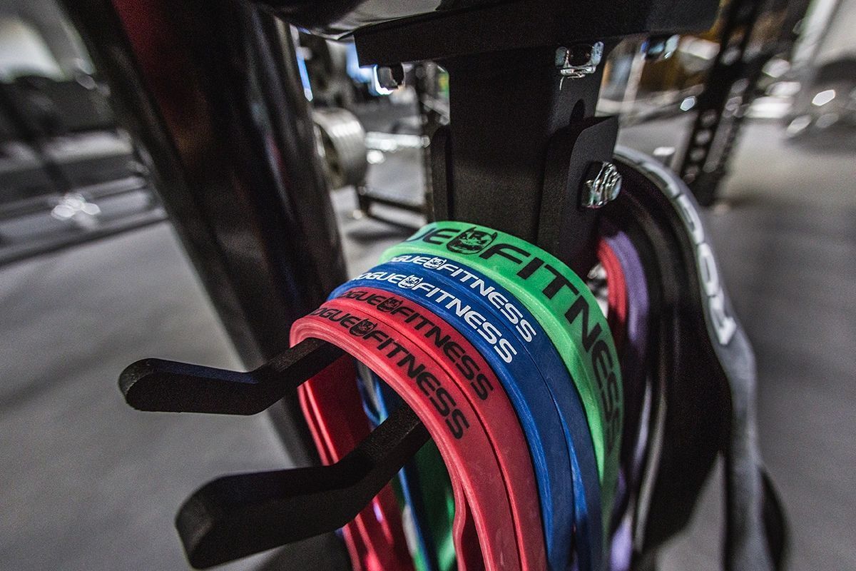 A bunch of resistance bands are hanging on a rack in a gym.