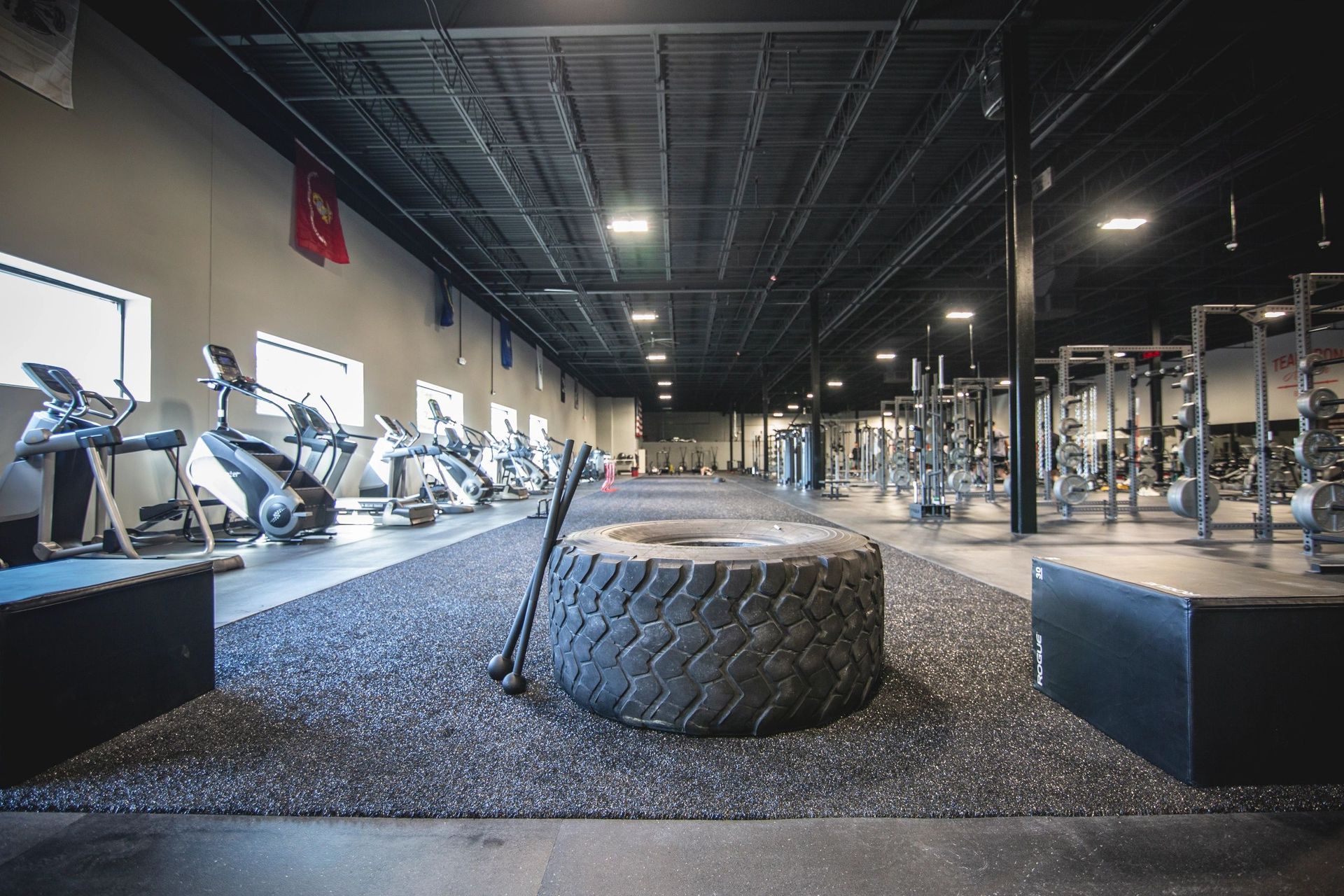 A large tire is sitting in the middle of a gym.