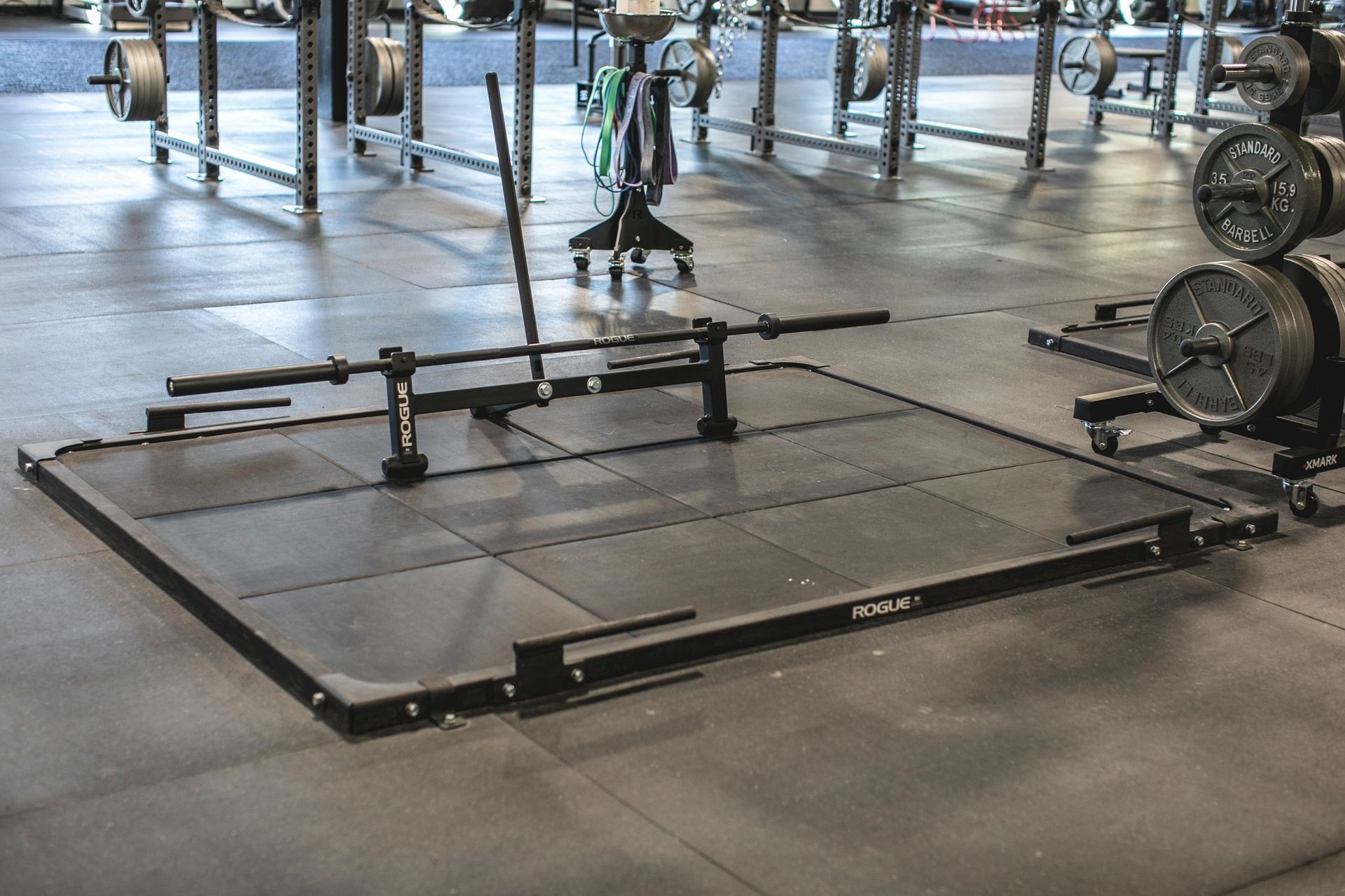 A squat rack is sitting on the floor of a gym.