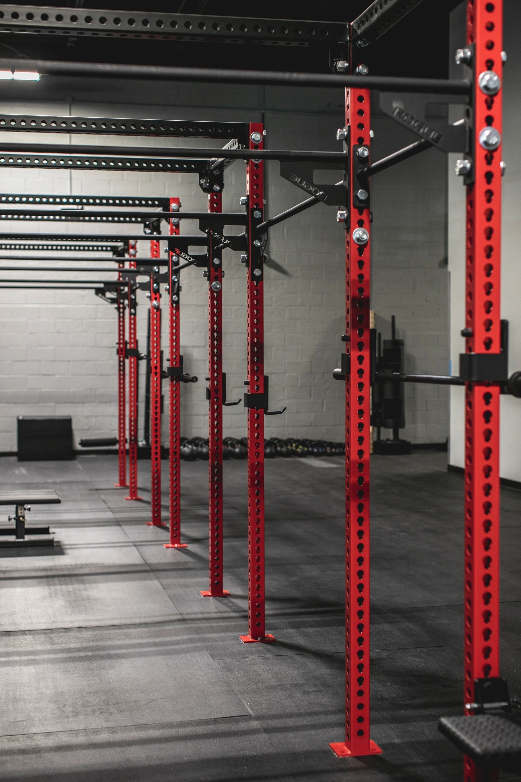 A row of red bars are lined up in a gym.
