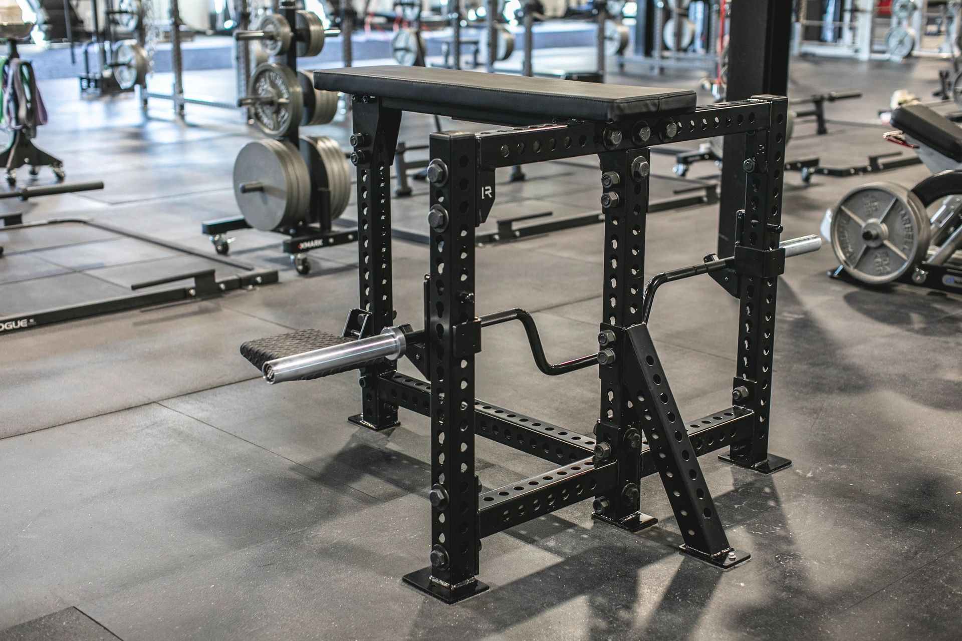 A bench in a gym with a barbell on it.