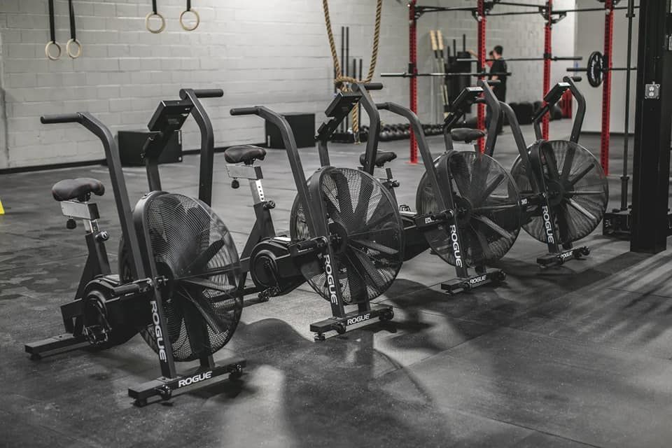 A row of exercise bikes are lined up in a gym.