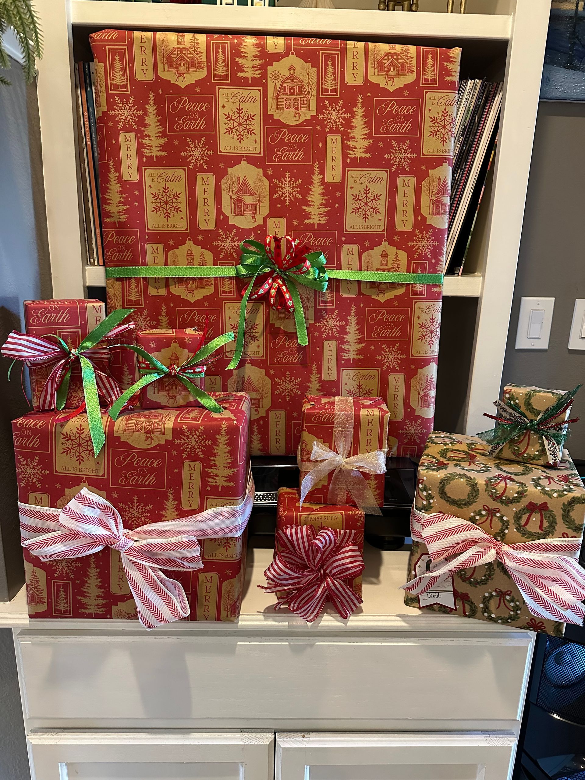 A collection of wrapped Christmas gifts on a granite countertop, featuring nutcracker and Santa-themed wrapping paper.