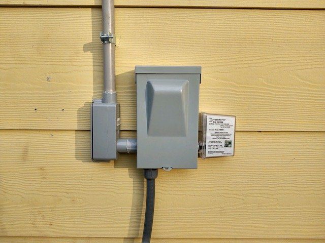 an electrical box is attached to the side of a house .