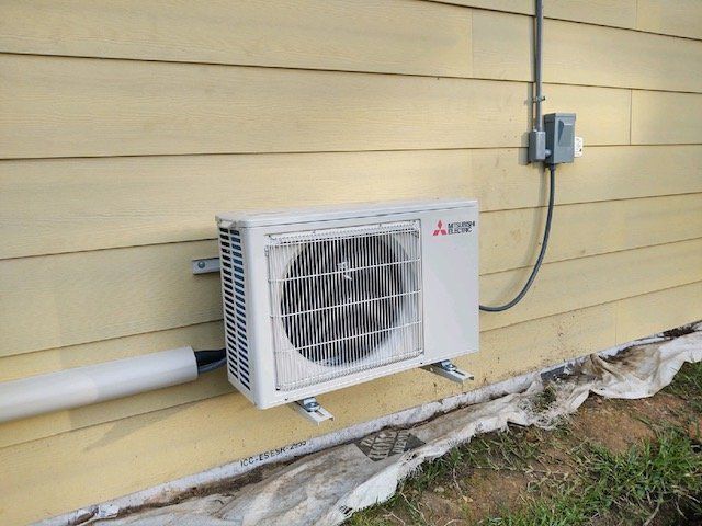a white air conditioner is mounted on the side of a house .