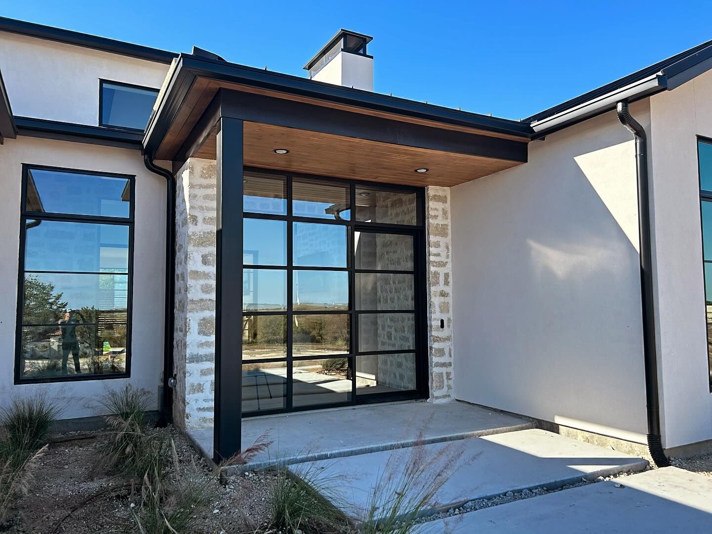 A modern house with a large porch and lots of windows.