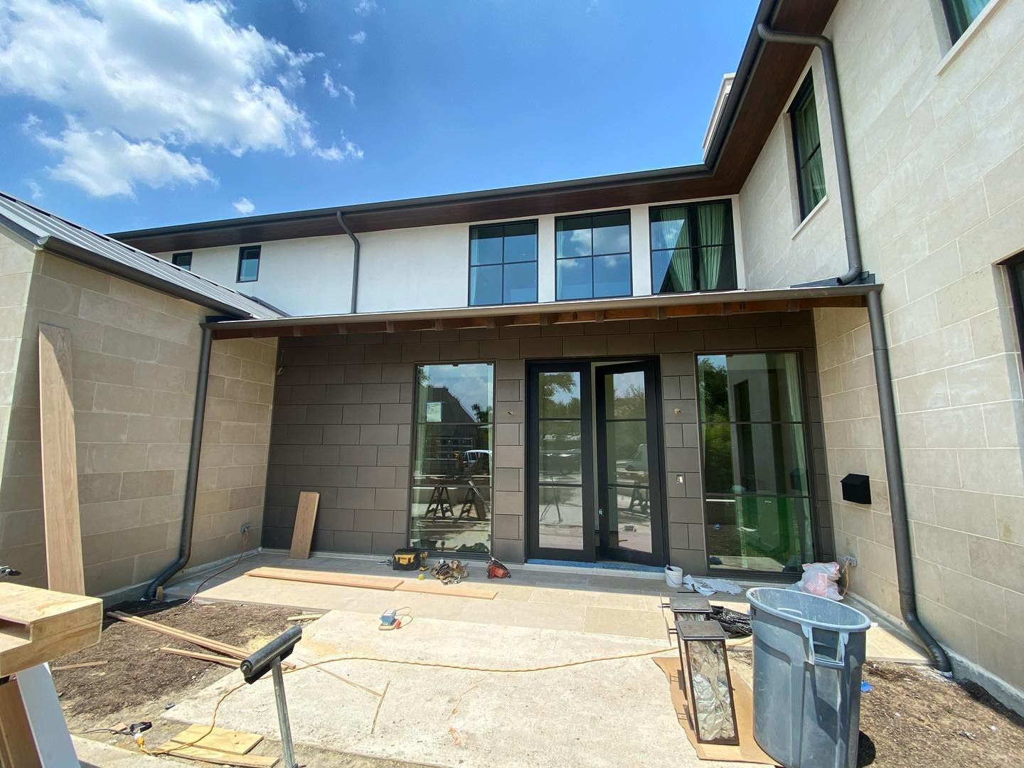 A large house with a lot of windows and doors is being built.