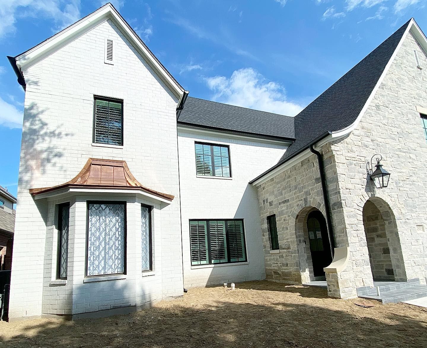 A large white brick house with a black roof