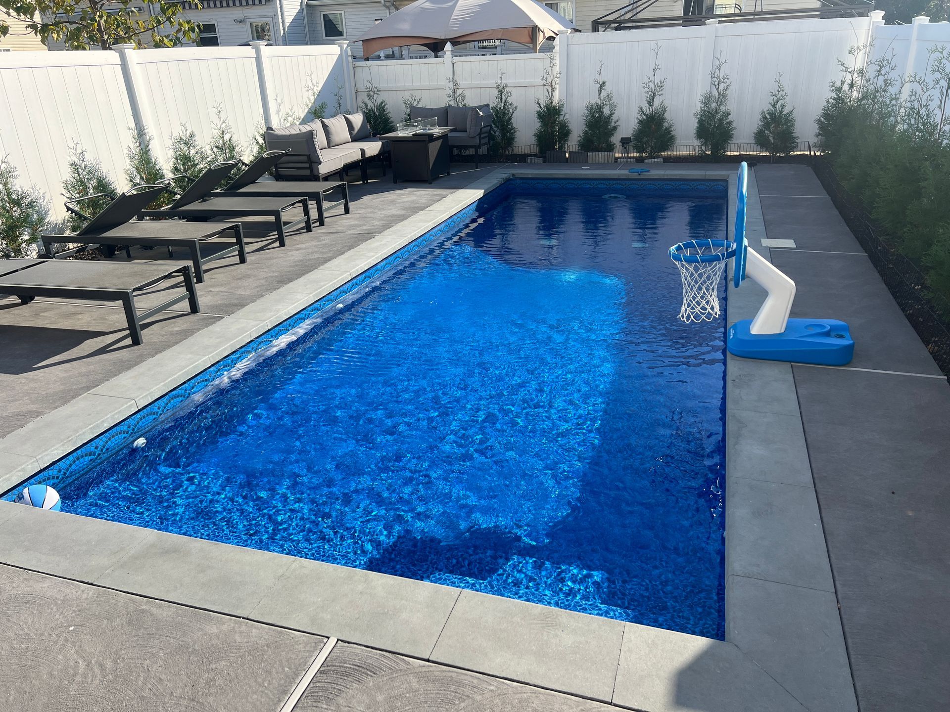 Modern backyard pool with stone waterfall features and purple accent lighting