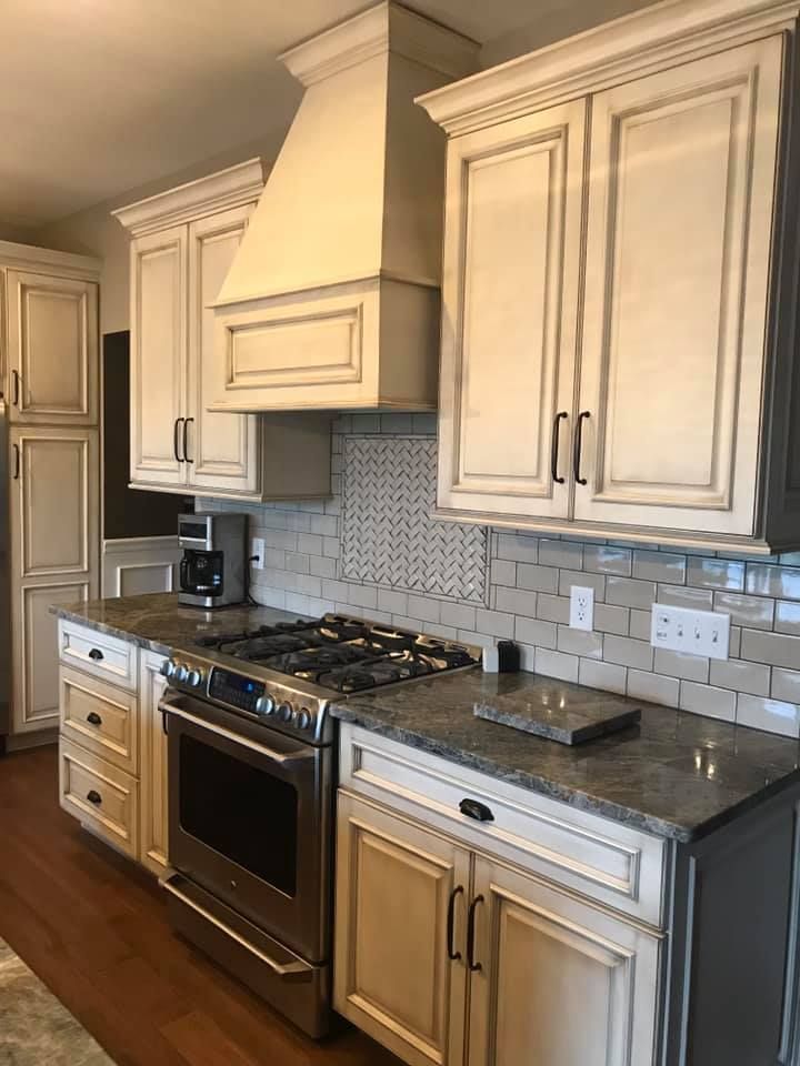A kitchen with white cabinets, stainless steel appliances, and granite counter tops.