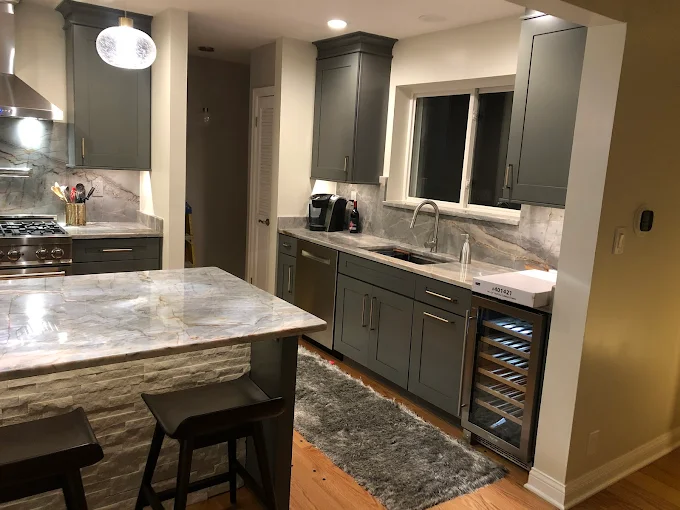A kitchen with gray cabinets and a wine cooler
