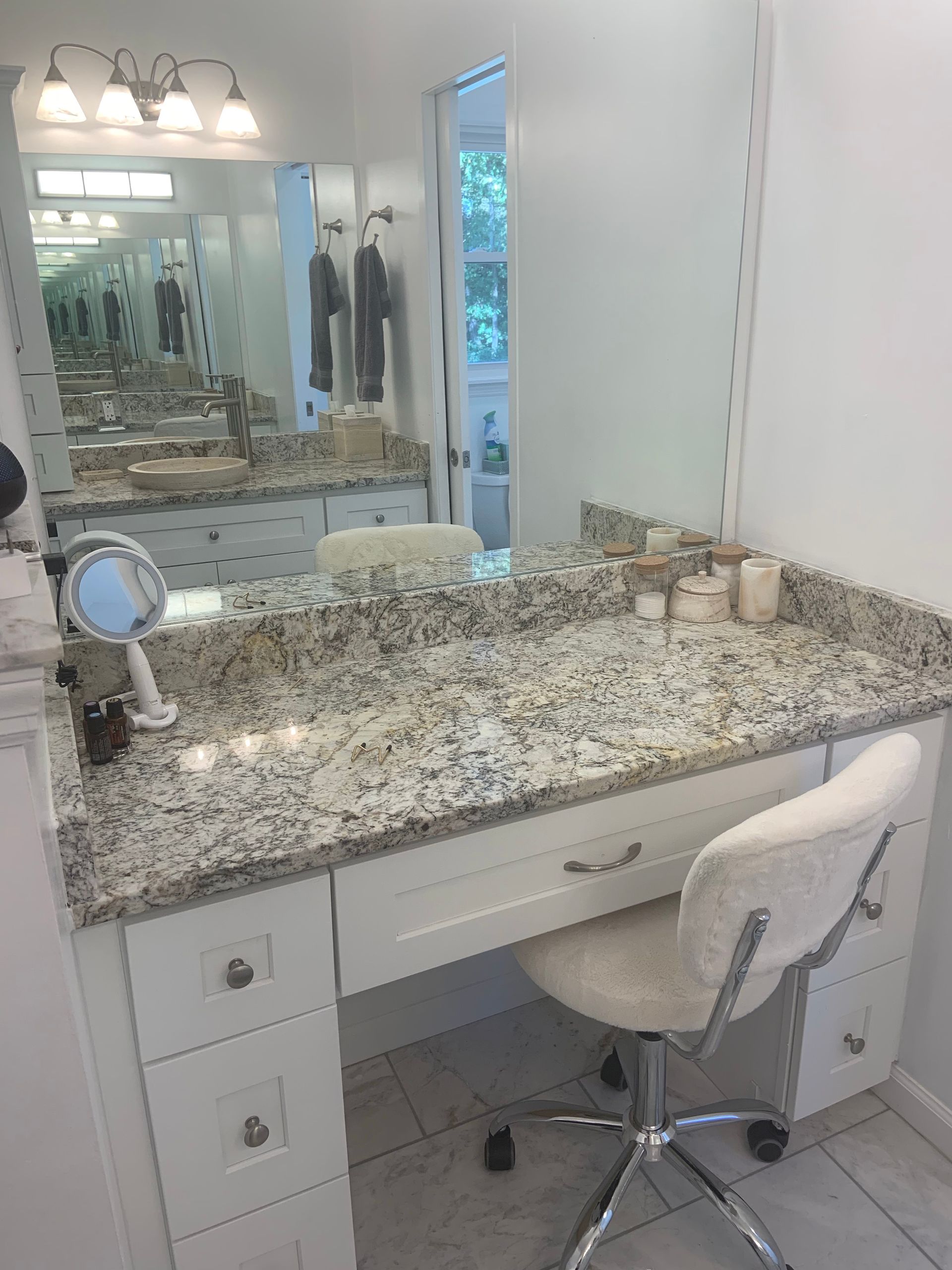 A bathroom vanity with a chair and a mirror
