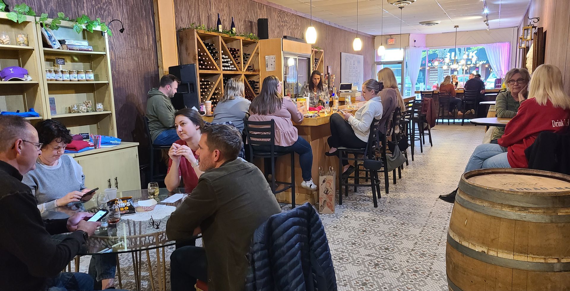 People dining in a cozy rustic restaurant with wooden barrels and warm lights.