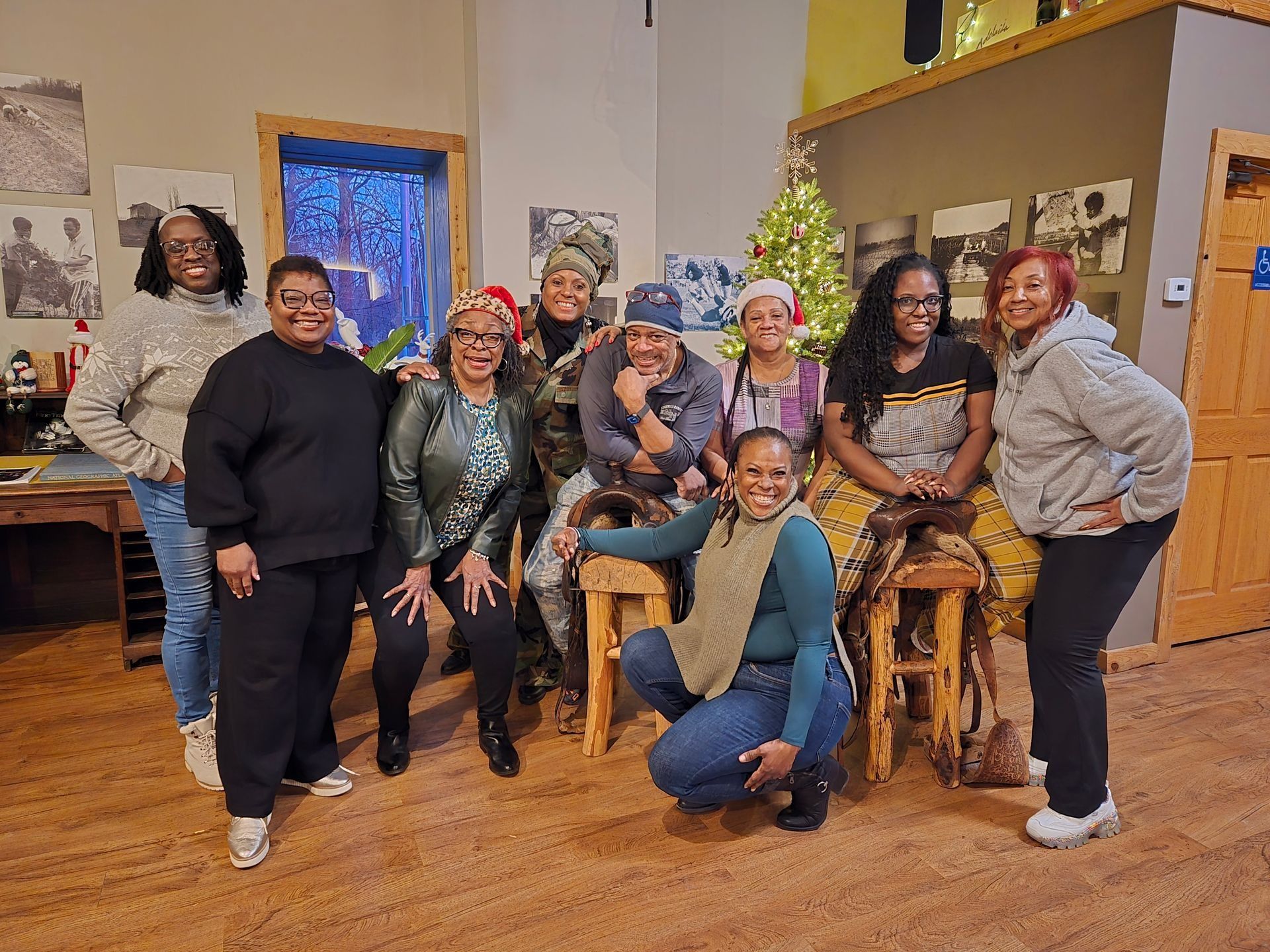 Group of people smiling and posing together in a cozy indoor room with warm lighting.