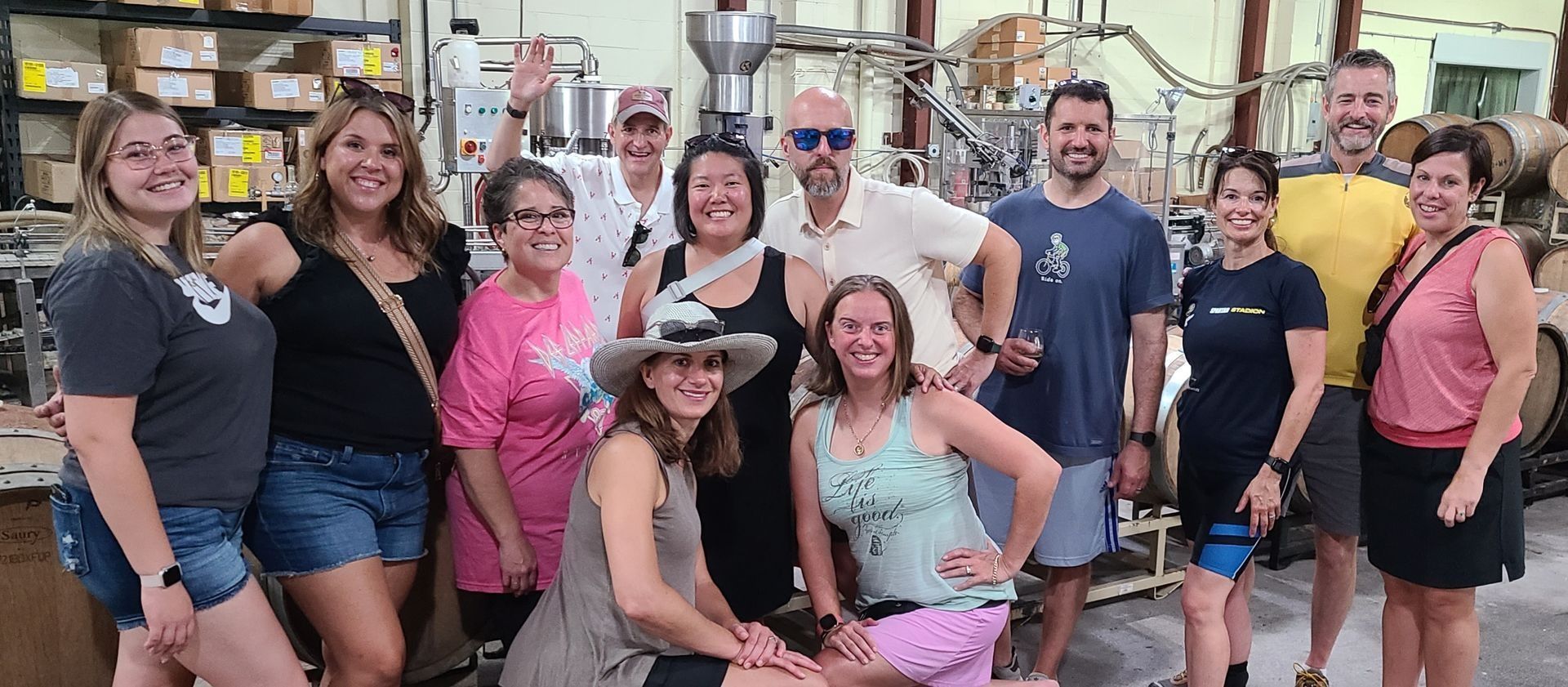 Group of people posing indoors in a market, some smiling and wearing hats and sunglasses.