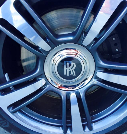 A black car with the door open is parked in front of a building