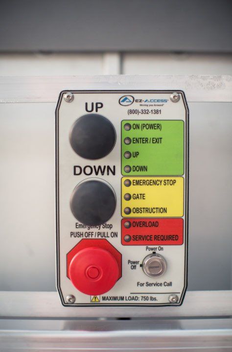 Control panel with buttons for up, down, emergency stop. Status lights: green, yellow, red.