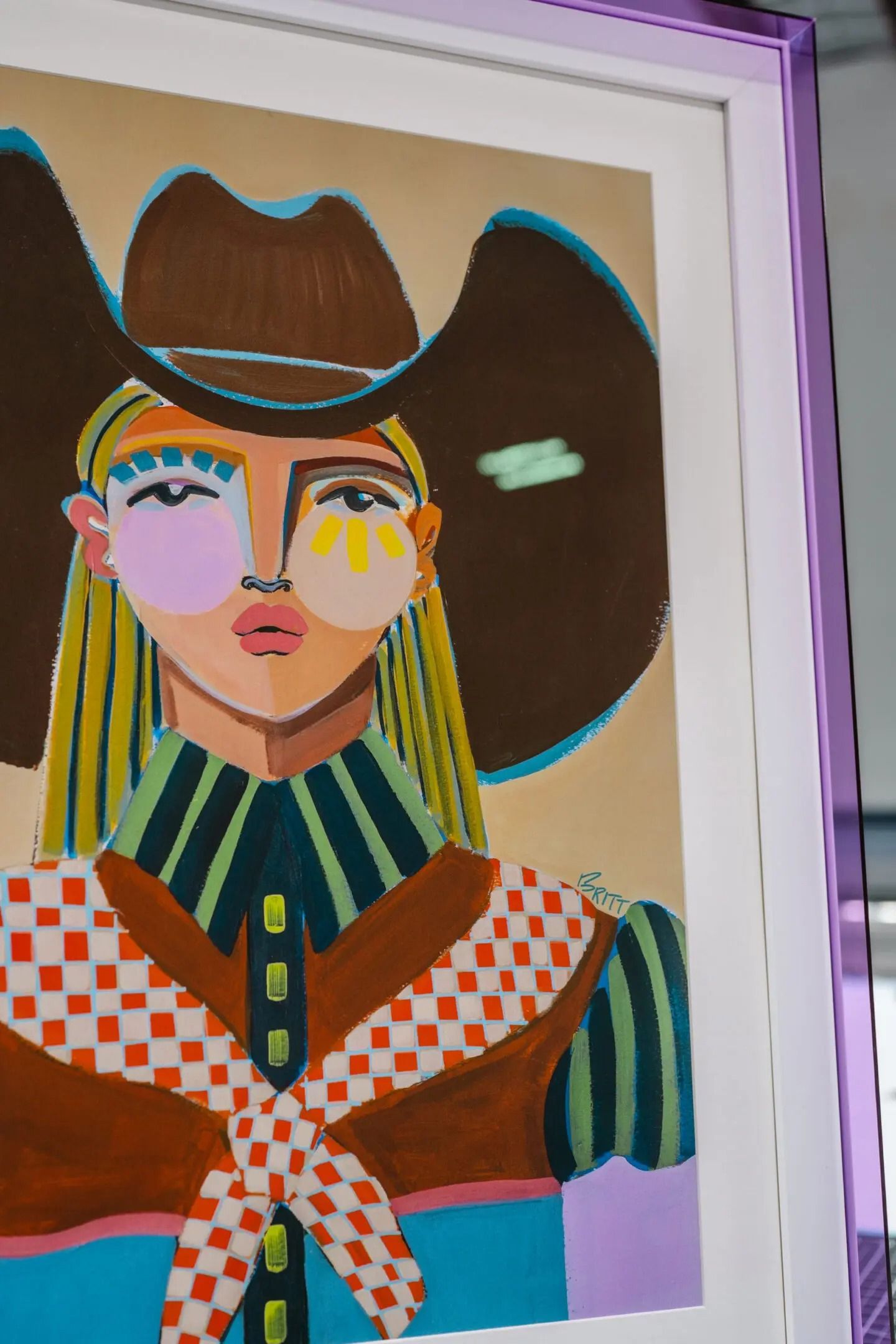 Stylized portrait with a hat, striped collar, and colorful geometric clothing on a framed canvas