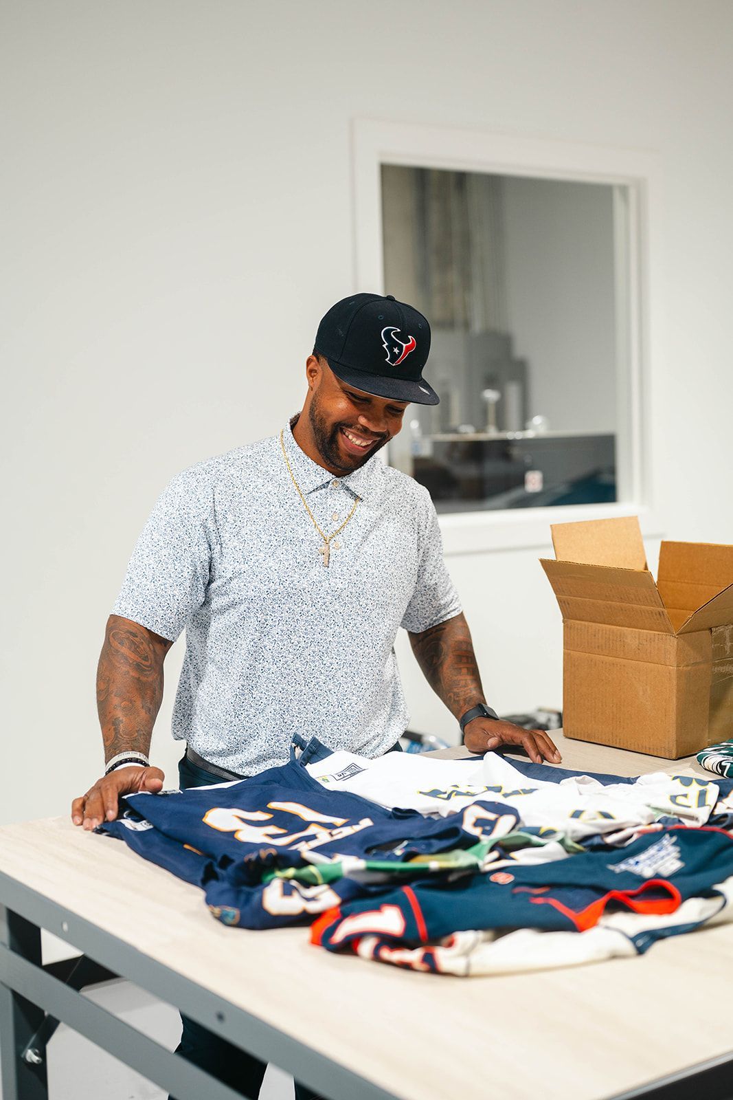 Person sorting clothes on a table beside open boxes in a bright room