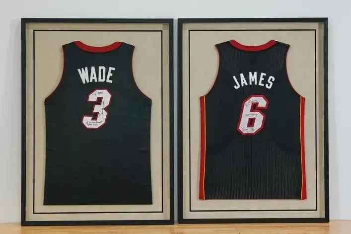 Framed Miami Heat jerseys of Wade 3 and James 6 side by side on a wall