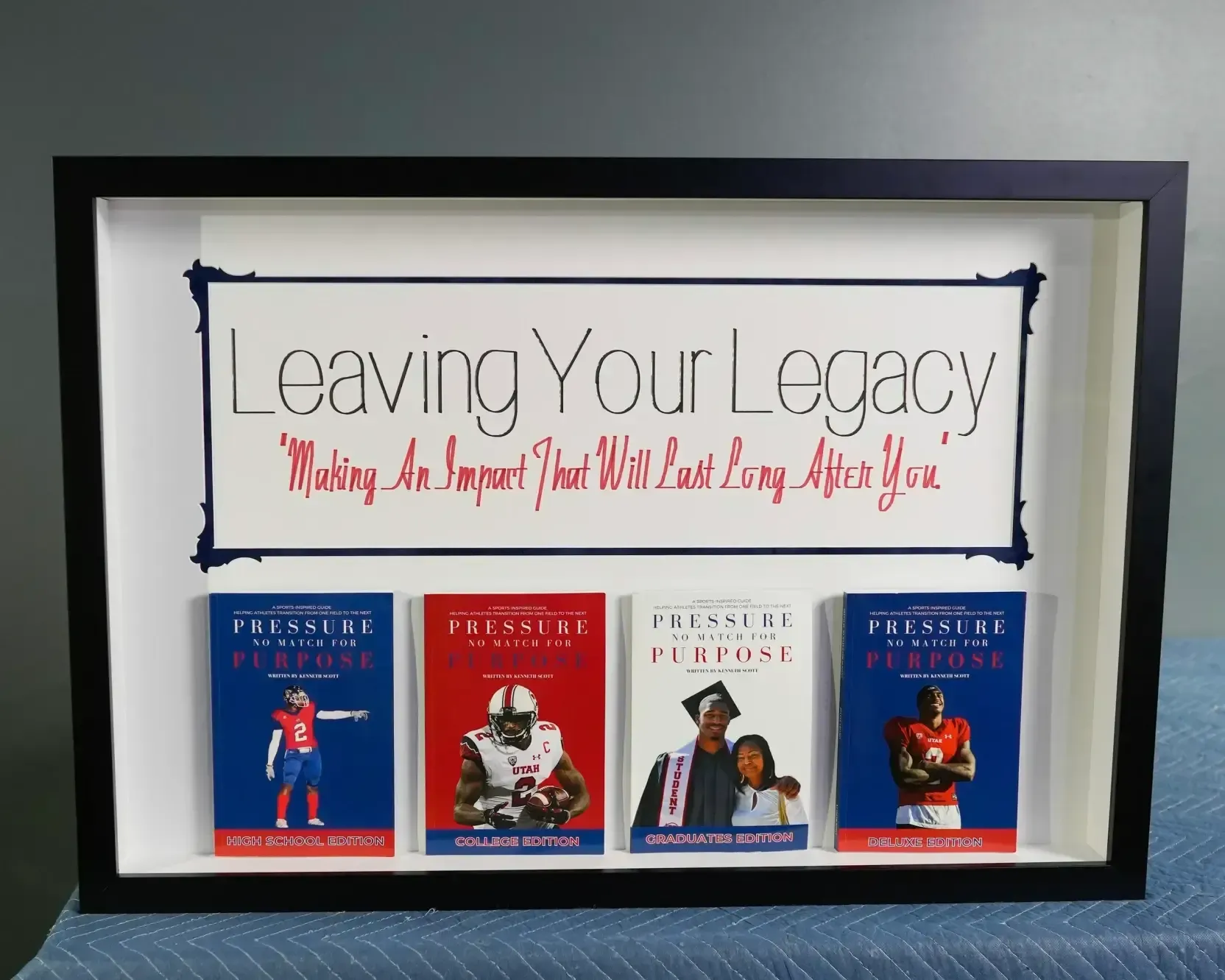 Framed “Leaving Your Legacy” display with four children’s books arranged beneath the sign.