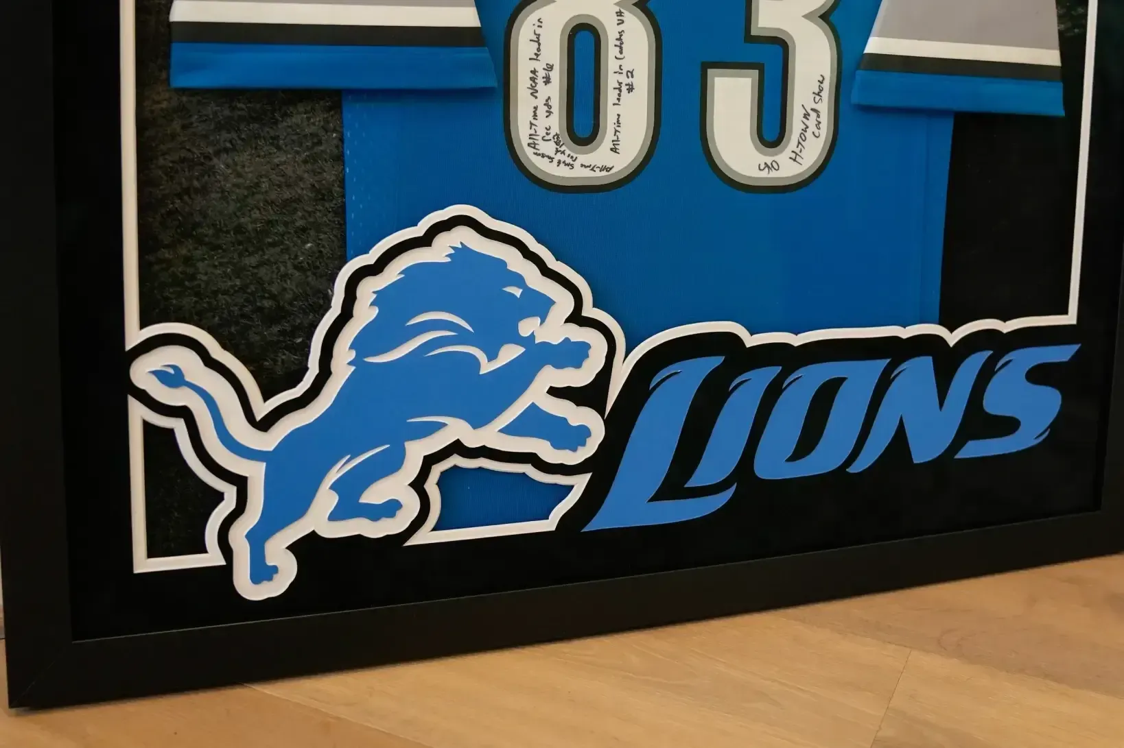 Detroit Lions framed jersey in blue, black, and white on a wall